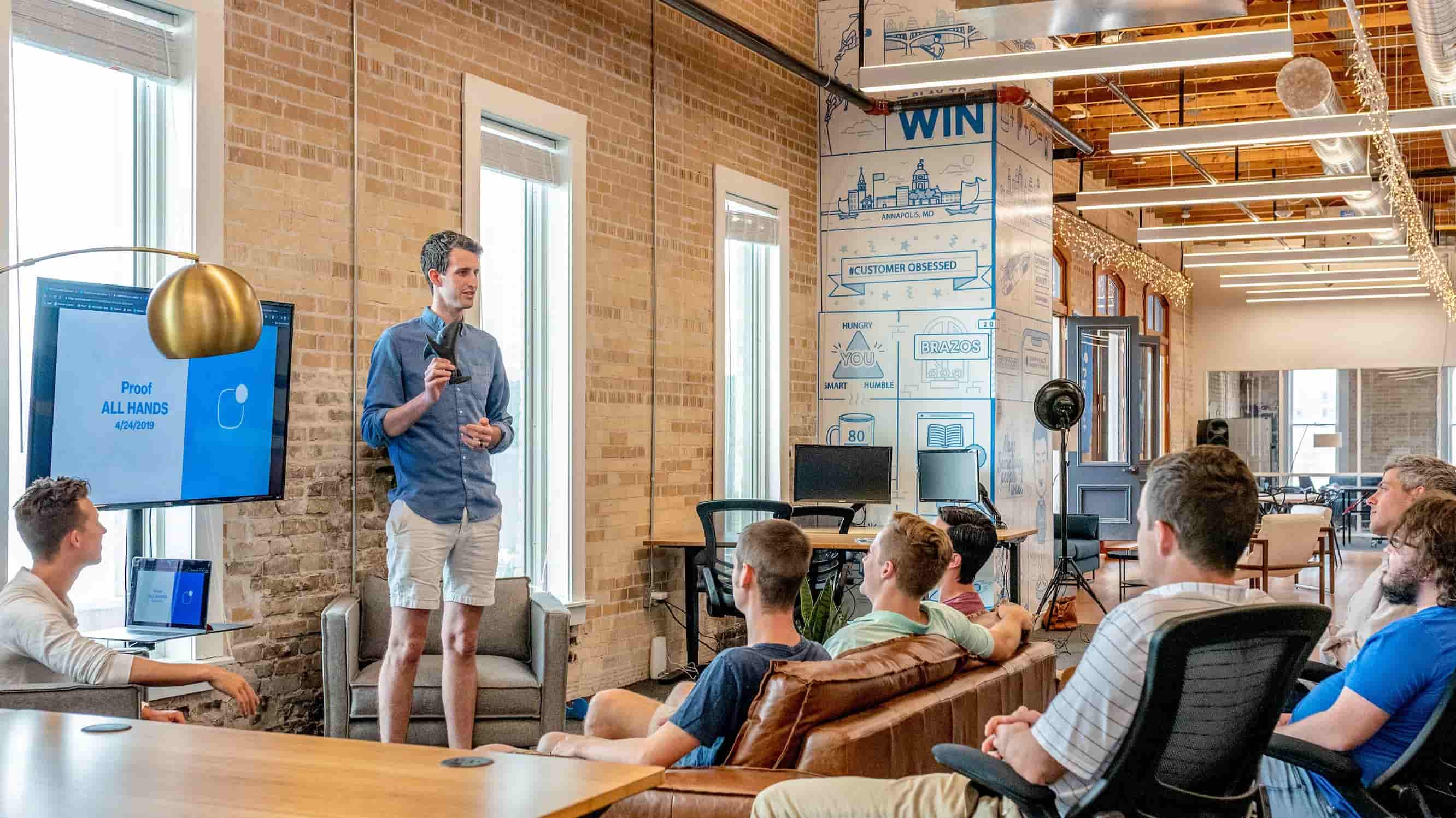 Man presenting in front of a group of men in a meeting.